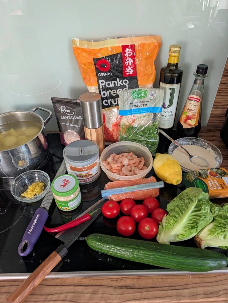 Würzige Lachs-Garnelen-Pflanzerl Cajun Style 10 Zutaten für Lachs-Garnelen-Pflanzerl: Frischer Lachs, Garnelen, Kartoffeln, Panko und Cajun-Gewürze auf einem Holzbrett