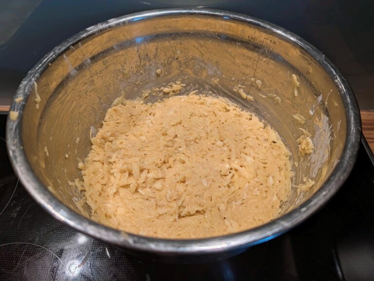 Frisch geraspelte Kartoffeln vermengt mit Mozzarella-Stifteln in einer Schu00fcssel fu00fcr die Ru00f6stimasse