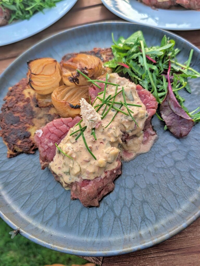 Heiß-Kaltes Steak Tatar 10 Fertig angerichtetes Steak Tatar auf einem Teller, garniert mit Kräutern und Eigelb.